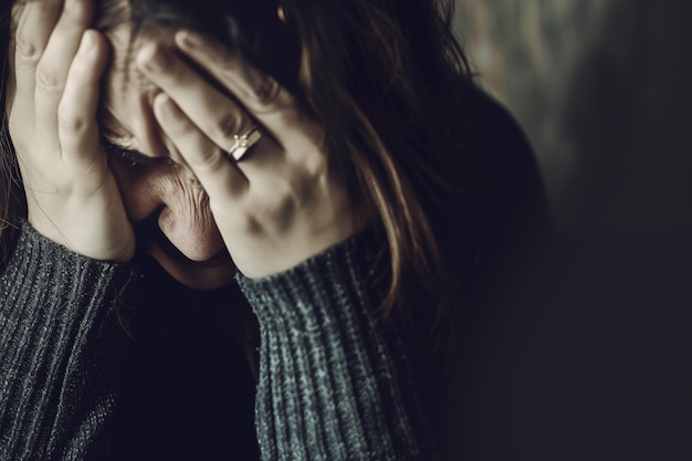 Retrato de una mujer de mediana edad cubriendo su cara con las manos en desesperación Concepto de depresión ruptura dolor pérdida de seres queridos