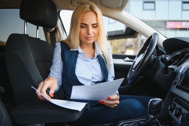 Retrato de mujer de mediana edad elegante de negocios en coche