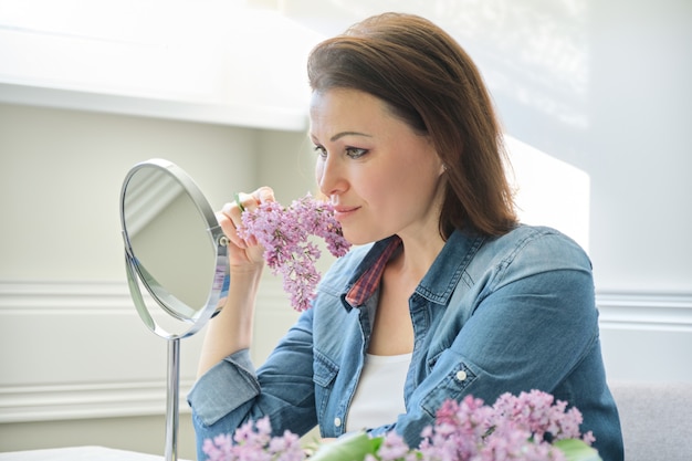 Retrato de mujer de mediana edad con espejo de maquillaje