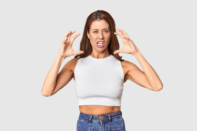 Foto retrato de una mujer de mediana edad en un estudio gritando de rabia