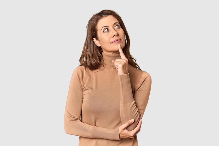 Foto retrato de una mujer de mediana edad en un estudio mirando hacia los lados con una expresión dudosa y escéptica