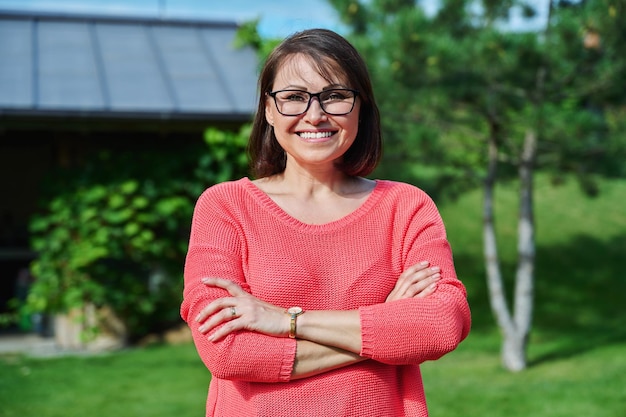 Retrato de una mujer de mediana edad sonriente mirando a la cámara al aire libre