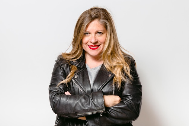 Retrato de mujer de mediana edad sonriente sobre fondo blanco.