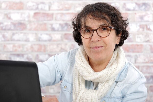 Retrato de mujer de mediana edad usando laptop