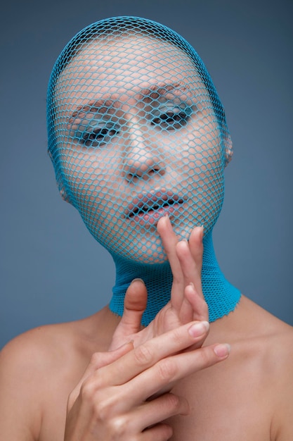 Retrato de mujer con medias azules en la cabeza contra el fondo azul. Retrato de moda de belleza