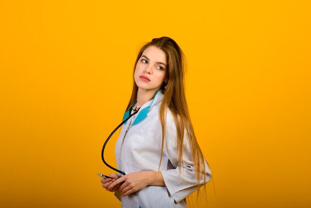 Retrato de mujer médico con estetoscopio en amarillo