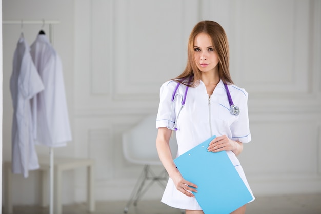 Retrato de mujer médico en el hospital, mirando a cámara.