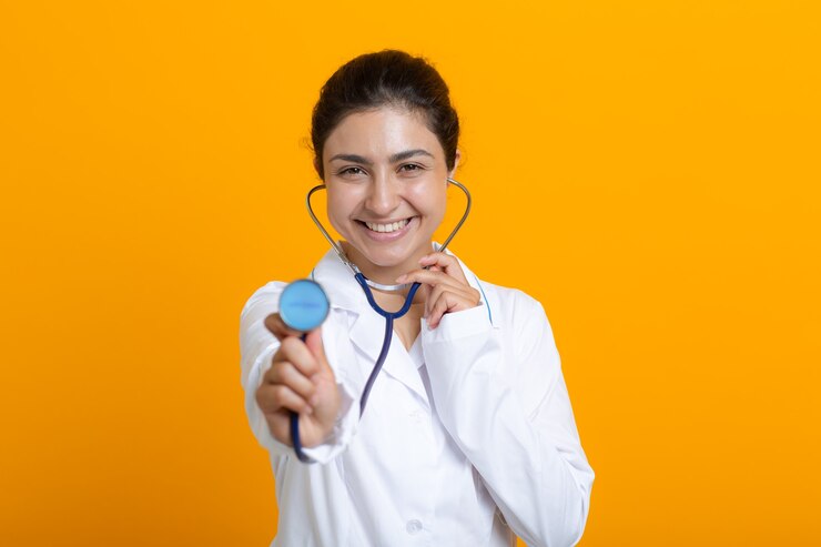 Retrato de mujer médico indio en bata médica blanca aislado sobre fondo amarillo