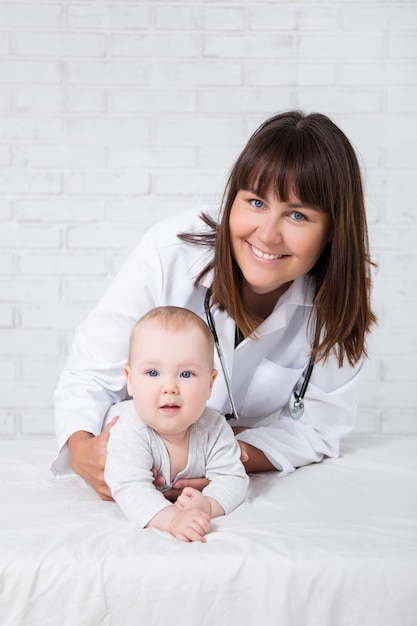 Retrato de mujer médico pediatra con lindo bebé