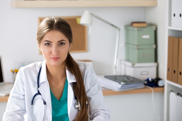 Retrato de mujer médico terapeuta de medicina sentado en su oficina