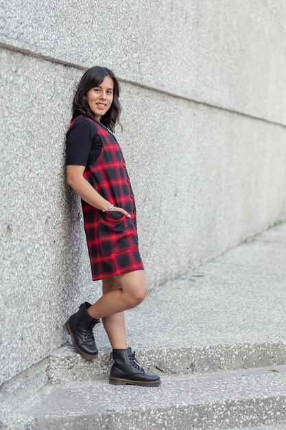 Retrato de una mujer mexicana con un vestido apoyado contra la pared de un museo con espacio para copiar