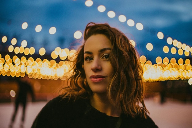 Retrato de una mujer mirando una lámpara iluminada