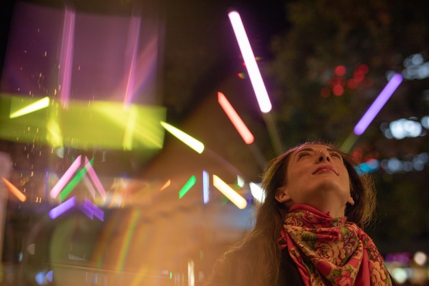 Foto retrato de una mujer mirando a las luces iluminadas