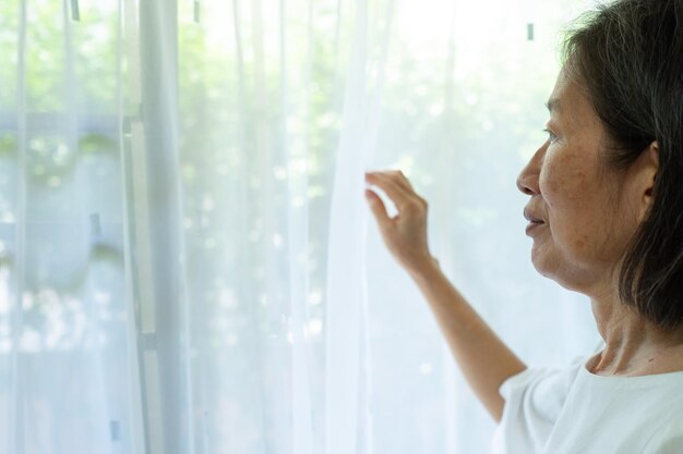 Retrato de una mujer mirando a través de una ventana de vidrio