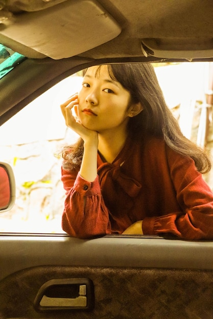 Retrato de una mujer mirando por la ventana de un coche
