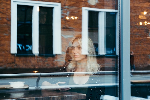 Retrato de una mujer mirando por la ventana