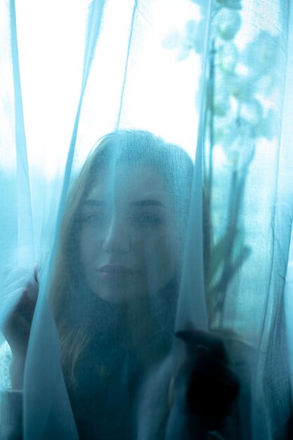 Foto retrato de una mujer mirando por la ventana