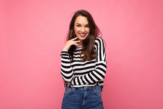 Retrato de mujer de moda alegre positiva en ropa casual aislado sobre fondo rosa con