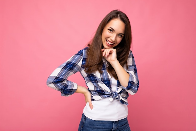 Retrato de mujer de moda alegre positiva en traje hipster aislado sobre fondo rosa con espacio de copia.