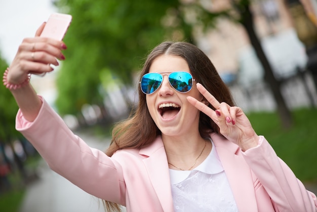 Retrato de mujer de moda haciendo selfie en gafas de sol