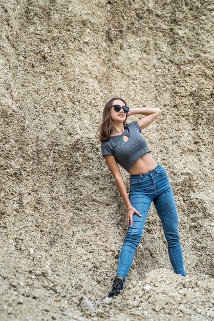 Retrato de mujer de moda hermosa viajera al desierto y relajarse en la arena, caluroso día de verano