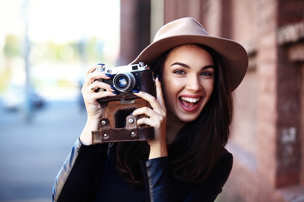 Retrato de mujer de moda de primer plano de joven muy de moda posando en la ciudad