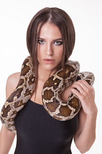 Foto retrato de mujer modelo posando en traje de baño con serpiente en estudio.