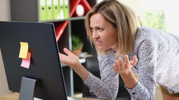 Retrato de mujer molesta mirando la pantalla de la computadora portátil con expresión enojada error de archivo de carga de trabajo todo