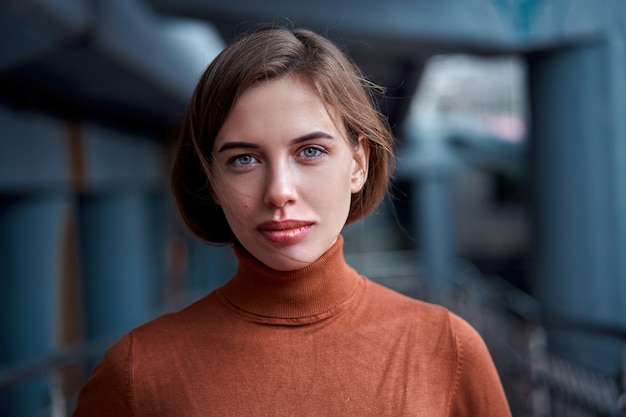 Retrato de mujer morena de confianza vestida de cuello alto marrón con atmósfera dramática