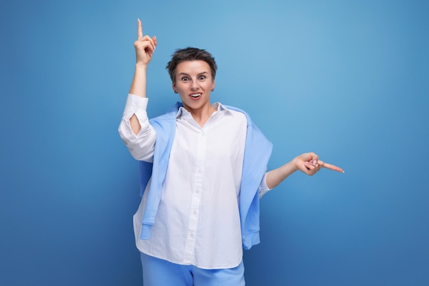 Retrato de mujer morena joven casual con corte de pelo corto en camisa blanca apuntando con el dedo