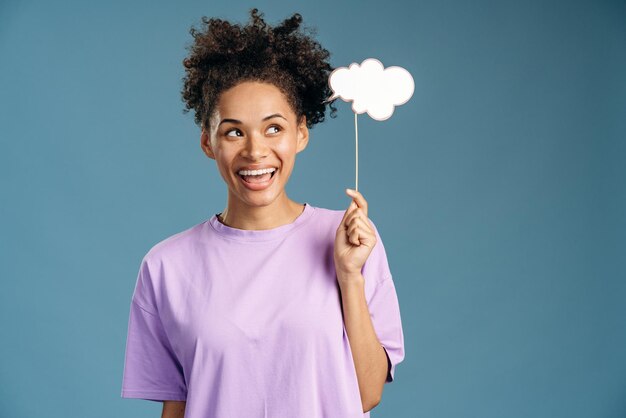 Retrato de mujer morena rizada con nube de papel en las manos teniendo algunos pensamientos