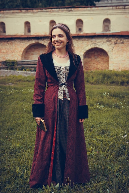 Foto retrato de mujer morena vestida con ropa barroca histórica con peinado antiguo al aire libre