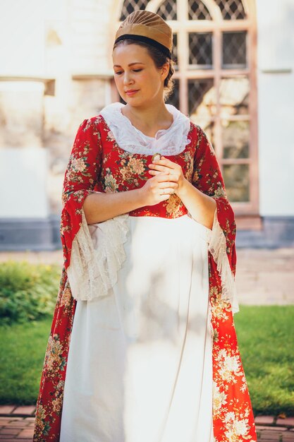 Retrato de mujer morena vestida con ropas rojas barrocas históricas