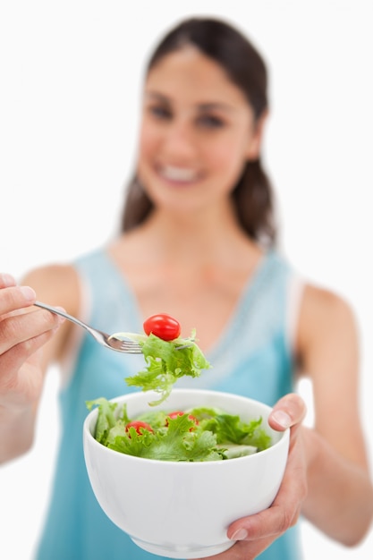 Retrato de una mujer mostrando una ensalada