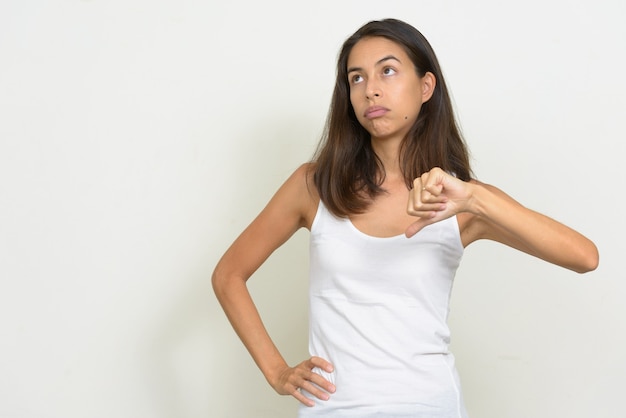 Retrato de mujer multiétnica estresada dando pulgares hacia abajo