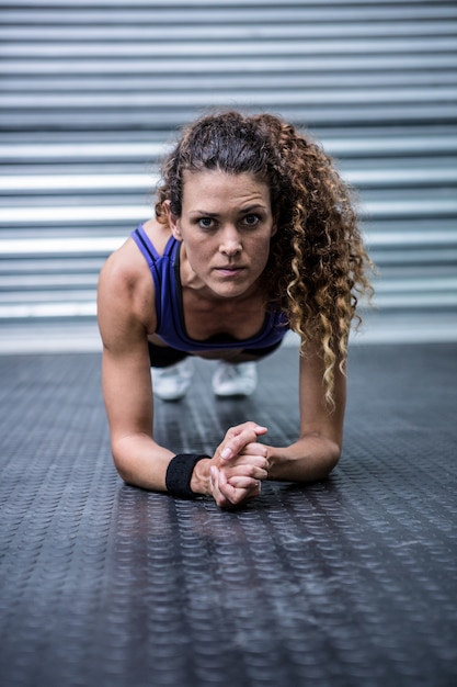 Foto retrato de mujer muscular haciendo flexiones