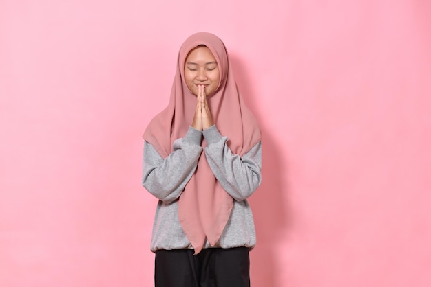 Retrato de mujer musulmana cerrando los ojos Concepto de amor esperanza y feliz Aislado sobre fondo rosa
