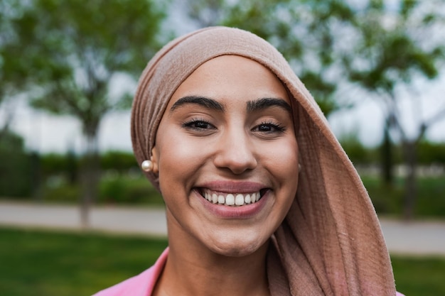 Retrato de mujer musulmana feliz sonriendo a la cámara al aire libre