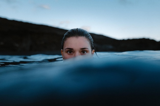 Retrato de una mujer nadando en el mar contra el cielo