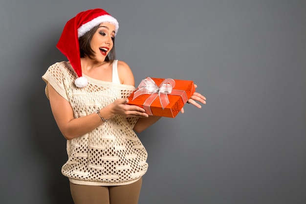 Retrato de mujer de Navidad con regalo de Navidad. Sonriente, mujer feliz