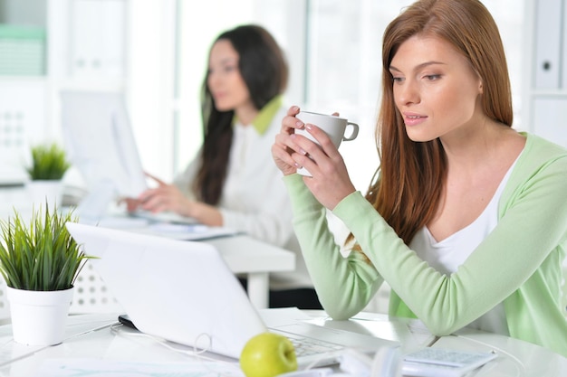 Retrato de una mujer de negocios agradable con una computadora portátil