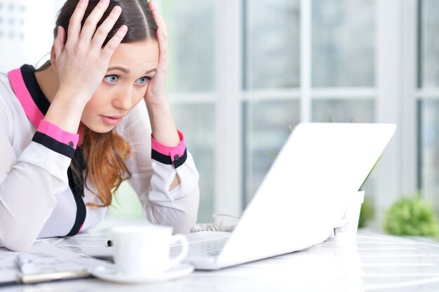 Retrato de una mujer de negocios agradable con un portátil en la oficina