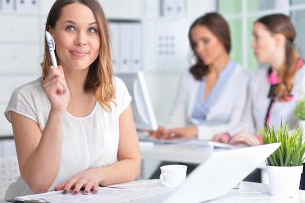 Retrato de una mujer de negocios agradable con un portátil en la oficina