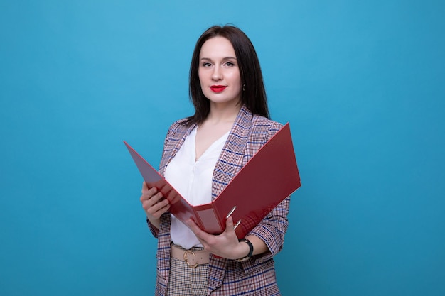 Retrato de una mujer de negocios con una carpeta roja sobre un fondo azul.