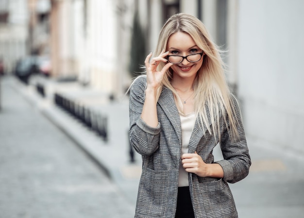 Retrato de una mujer de negocios en la ciudad. Chica rubia joven en ropa de negocios