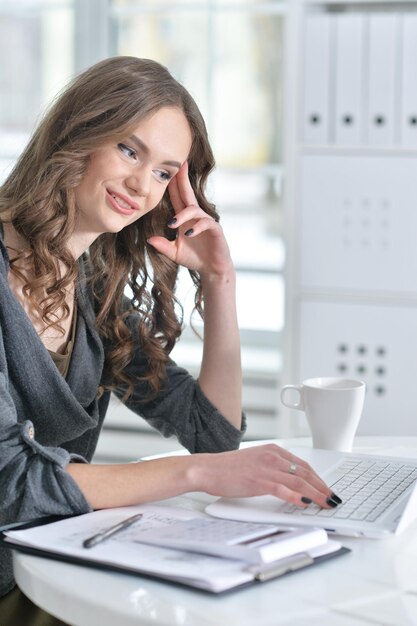 Retrato de una mujer de negocios con una computadora portátil en la oficina