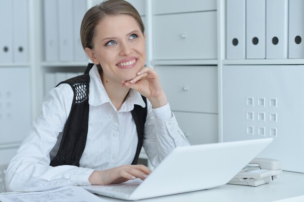 Retrato de una mujer de negocios con una computadora portátil en la oficina