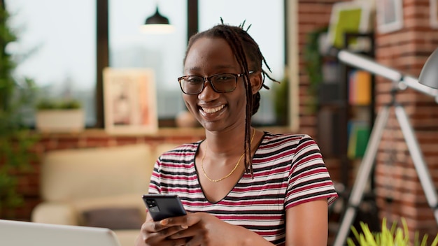 Retrato de una mujer de negocios enviando mensajes de texto por teléfono móvil, usando una aplicación de redes sociales en un descanso de trabajo remoto. Empleada hablando en la red en línea usando el sitio web en línea en casa.