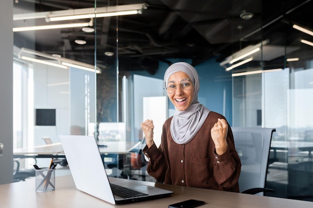 Retrato de una mujer de negocios exitosa en una mujer musulmana hijab que trabaja dentro de la oficina usando una computadora portátil en