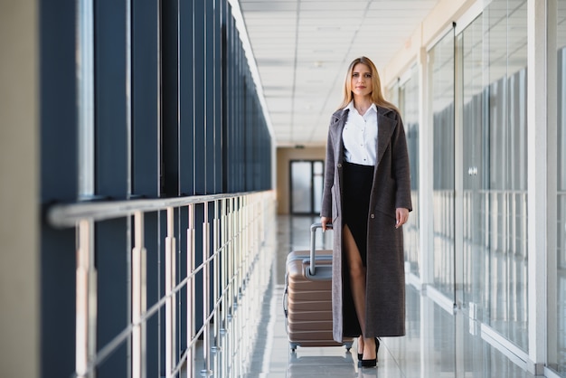 Retrato de mujer de negocios exitosa viajando con estuche en el aeropuerto